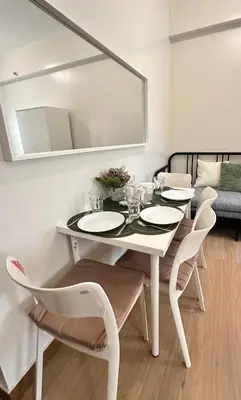 a white dining room with a white table and chairs at Enchantress Abode in Trece Martires