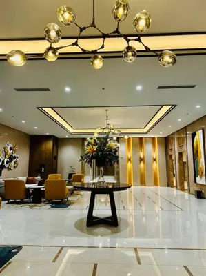 a lobby with a table with a vase of flowers on it at 10G Cozy Condo at Park McKinley West near Venice Mall in Manila