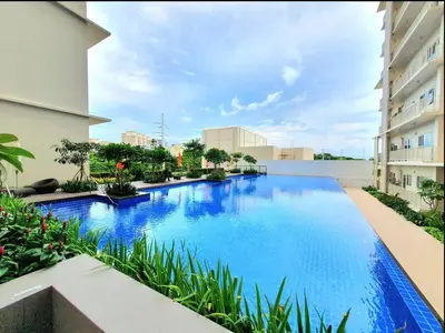 a large swimming pool in the middle of a building at 10G Cozy Condo at Park McKinley West near Venice Mall in Manila