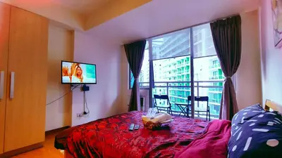 a room with a bed and a tv and a window at Azure Urban Resort Residence in Manila