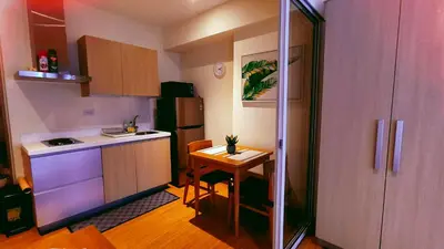 a small kitchen with a table and a refrigerator at Azure Urban Resort Residence in Manila