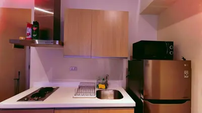 a small kitchen with a refrigerator and a sink at Azure Urban Resort Residence in Manila