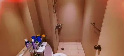 a bathroom with a shower with a toilet and toothbrushes at Azure Urban Resort Residence in Manila