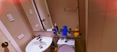 a bathroom with a sink and a toilet and a mirror at Azure Urban Resort Residence in Manila