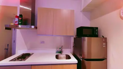 a small kitchen with a refrigerator and a sink at Azure Urban Resort Residence in Manila