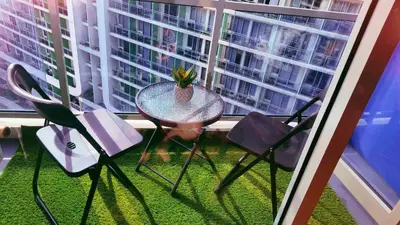 a table with chairs and a plant on a balcony at Azure Urban Resort Residence in Manila