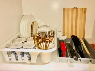 a shelf with plates and other kitchen utensils at Kate's Place in Mall of Asia Complex in Manila