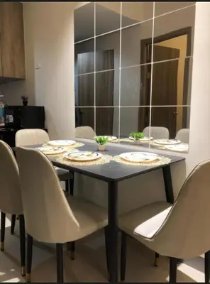 a dining room table with chairs and a mirror at Kate's Place in Mall of Asia Complex in Manila