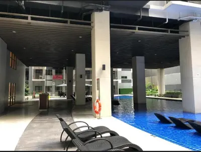 a person standing in front of a swimming pool in a building at Kate's Place in Mall of Asia Complex in Manila