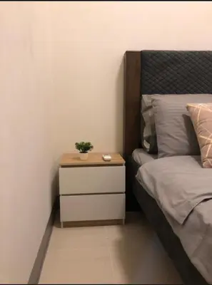 a bedroom with a bed and a nightstand with a plant on it at Kate's Place in Mall of Asia Complex in Manila