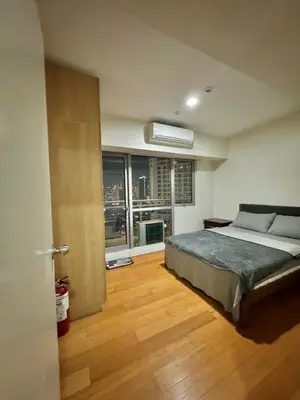 a bedroom with a bed and a large window at The Home Ikigai in Manila