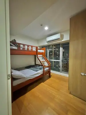 a bedroom with two bunk beds and a window with a view at The Home Ikigai in Manila