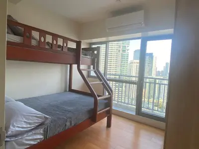 a bedroom with a bunk bed with a view of a city at The Home Ikigai in Manila