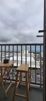 a table and bench on a balcony with a view of an airport at Hideouts & Hangouts in Manila