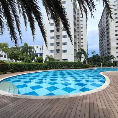 a swimming pool with blue tiles on a wooden deck at Hideouts & Hangouts in Manila
