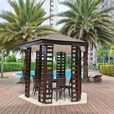 a wooden gazebo with chairs and a table and chairs at Hideouts & Hangouts in Manila