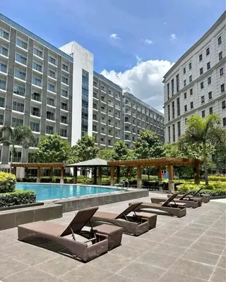 a large building with a swimming pool in front at 81 Newport Boulevard-Hyuna Place, Across NAIA T3 in Manila