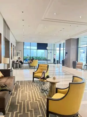a lobby of a building with yellow chairs and tables at 81 Newport Boulevard-Hyuna Place, Across NAIA T3 in Manila