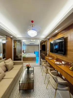 a living room with a couch and a table at Grand Suites Shore 3 Residences in Manila