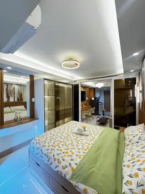 a bedroom with a large bed and a bathroom at Grand Suites Shore 3 Residences in Manila
