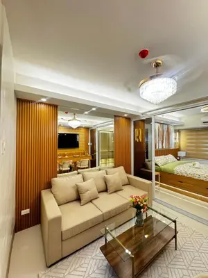 a living room with a couch and a bedroom at Grand Suites Shore 3 Residences in Manila
