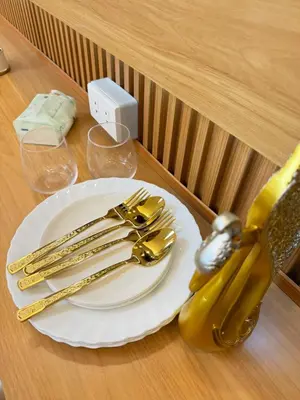 a plate with gold utensils on a table at Grand Suites Shore 3 Residences in Manila
