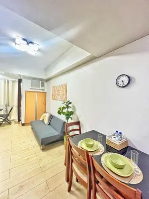 a living room with a table and chairs and a couch at Nara Homes at Palm Tree Villas in front of NAIA Terminal 3 in Manila