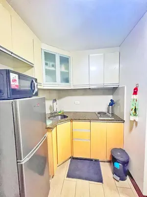 a small kitchen with a stainless steel refrigerator at Nara Homes at Palm Tree Villas in front of NAIA Terminal 3 in Manila