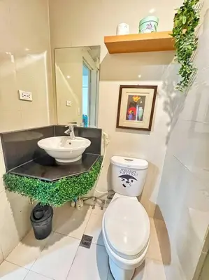 a bathroom with a toilet and a sink at Nara Homes at Palm Tree Villas in front of NAIA Terminal 3 in Manila