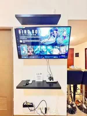 a flat screen computer monitor hanging on a wall at Nara Homes at Palm Tree Villas in front of NAIA Terminal 3 in Manila