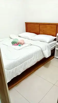 a bed with white sheets and a wooden headboard at Y&N Staycation Cozy and Aesthetic Unit near to NAIA Airport in Manila