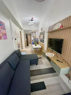 a living room with a blue couch and a tv at Y&N Staycation Cozy and Aesthetic Unit near to NAIA Airport in Manila