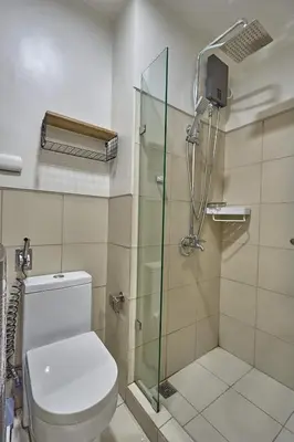 a bathroom with a toilet and a glass shower at Y&N Staycation Cozy and Aesthetic Unit near to NAIA Airport in Manila