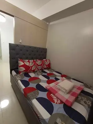 a bedroom with a bed with a colorful comforter at Sea Residences Karen's Staycation in Manila