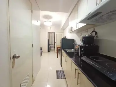 a kitchen with a black counter top and a sink at Sea Residences Karen's Staycation in Manila