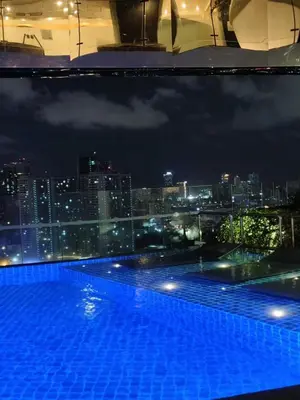 a swimming pool with a view of a city at night at Christine Suites PH 1BR with Balcony Gramercy Residences Makati in Manila