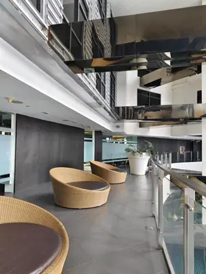 a lobby with chairs and tables in a building at Christine Suites PH 1BR with Balcony Gramercy Residences Makati in Manila
