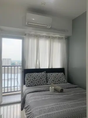a bedroom with a bed and a window with a view at Smdc south Residences almanza uno in Manila