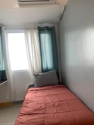 a small bed in a small room with a window at Smdc south Residences almanza uno in Manila