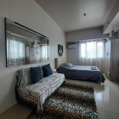 a bedroom with a couch and a bed and a mirror at ApartHotel Tower22307 in Manila