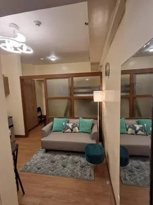 a living room with a couch with pillows on it at Cozy Home beside mall,MRTBoniEDSA in Manila
