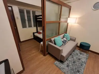 a living room with a couch and a mirror at Cozy Home beside mall,MRTBoniEDSA in Manila