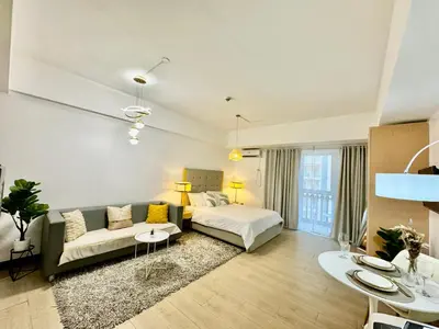 a large living room with a bed and a couch at Cozy home Near NAIA & BGC in Manila