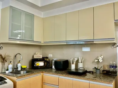 a kitchen with white cabinets and a sink at Cozy home Near NAIA & BGC in Manila