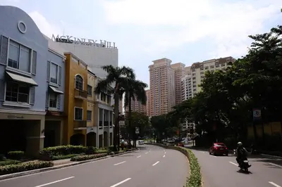 a person riding a scooter down a city street at Cozy home Near NAIA & BGC in Manila