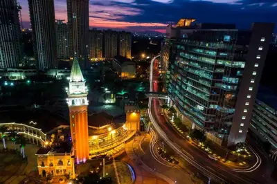 a city skyline at night with a clock tower at Cozy home Near NAIA & BGC in Manila