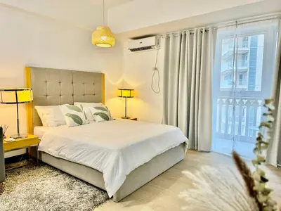 a bedroom with a bed and a large window at Cozy home Near NAIA & BGC in Manila
