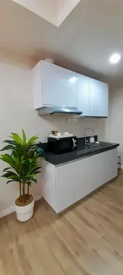 a kitchen with white cabinets and a potted plant at La Nobleza Manila in Manila