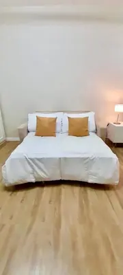 a white bed with two pillows on it in a room at La Nobleza Manila in Manila