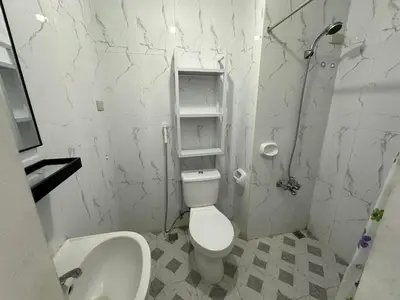 a white bathroom with a toilet and a sink at B&CH RESIDENCE Transient in Calamba